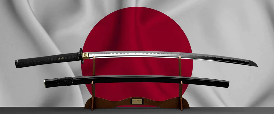 Japońska katana na tle flagi Japonii. Esej o historii i ewolucji samurajskiego miecza - jak kultura Japonii doszła do dzisiejszych dzieł sztuki samurajskich katan.
