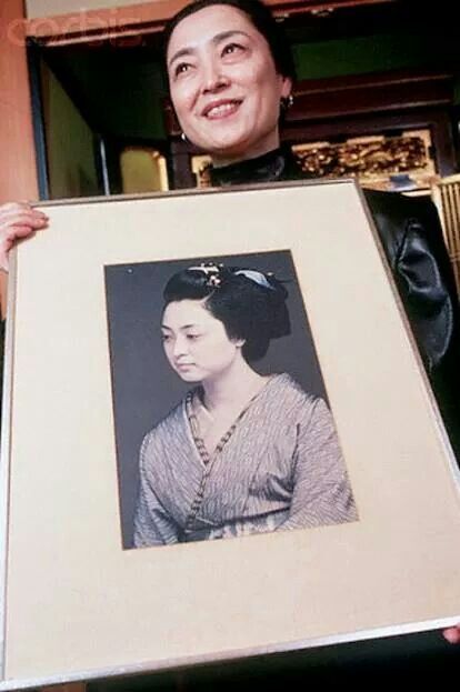 Mineko Iwasaki showing her photo from youth as a geisha. Article about 20 century most famous geisha Mineko Iwasaki. Geishas as artisans and keepers of Japanese culture and tradition. Mineko Iwasaki standing against Arthur Golden regarding defamation case in Memoirs of Geisha.