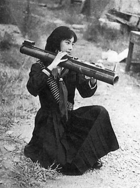 Fusako Shigenobu - młoda Japonka - terorrystka przymieża bazukę. Artykuł o JRA (Japanese Red Army) - ekstremistycznej organizacji terrorystycznej walczącej w imię komunizmu.