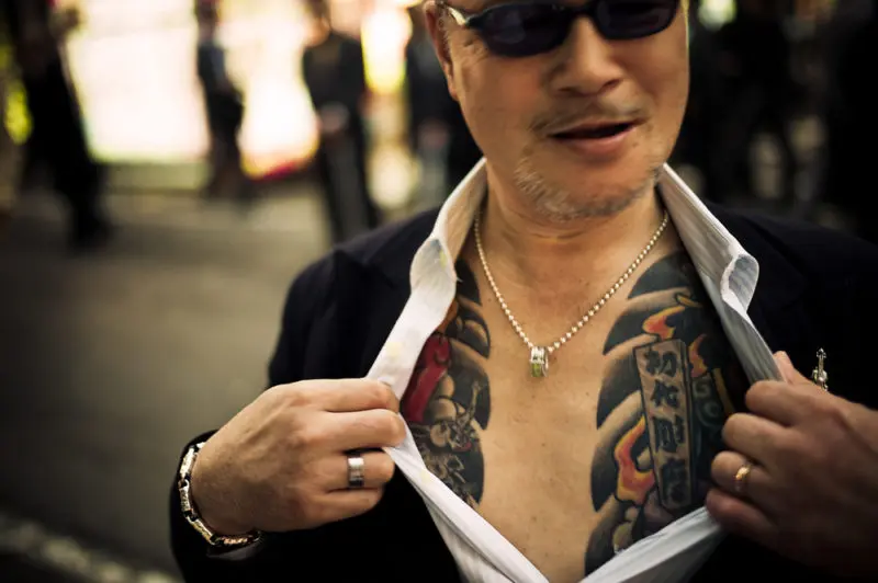 Yakuza fighter w Shinjuku, Tokyo, Japonia. Esej o japońskiej, 400-letniej mafii: Yakuza. Co oznacza nazwa, jaka jest historia i współczesna działalność yakuzy w Japonii i na świecie.